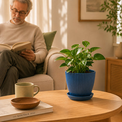 homme lisant un livre avec pot de fleur sur table